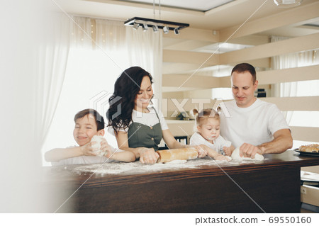 the family makes cakes. the children were covered in flour. dinner at the bakery. feast in the kitchen 69550160