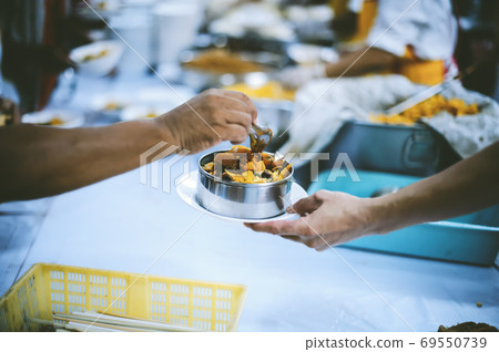 Charity food, Food for the poor hungry volunteers offering food to help the homeless Charity food, Food for the poor hungry volunteers offering food to help the homeless 69550739
