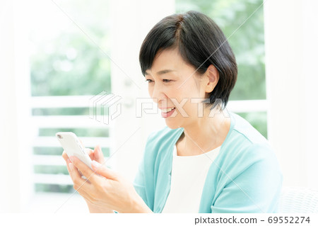 Middle woman making a video call on her smartphone Middle woman making a video call on her smartphone 69552274