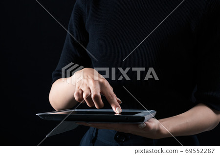 A woman who operates a tablet PC 69552287