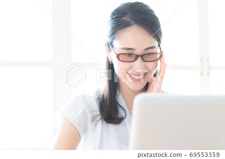 在商務計算機上工作時戴藍色輕便眼鏡的女人 在商務計算機上工作時戴藍色輕便眼鏡的女人 69553359