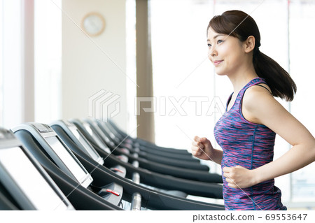 婦女在體育館和跑步機上跑步 69553647