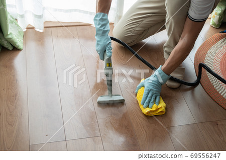 Husband cleaning flooring with steam cleaner Husband cleaning flooring with steam cleaner 69556247