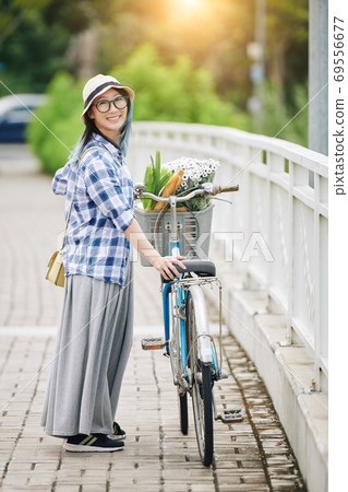 Chinese woman standing next to her bicycle Chinese woman standing next to her bicycle 69556677