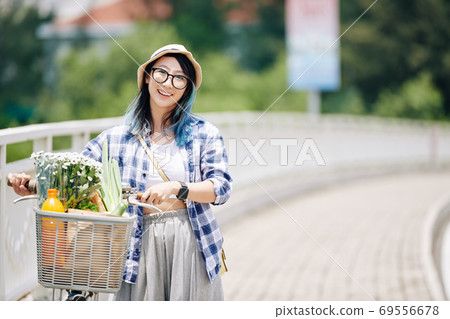 Asian woman walking with bicycle Asian woman walking with bicycle 69556678