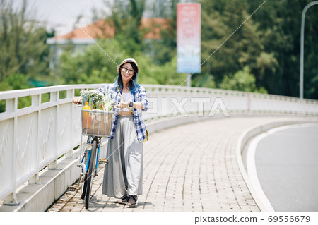 Woman walking with bicycle 69556679