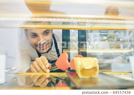 Waiter taking cake from showcase 69557436