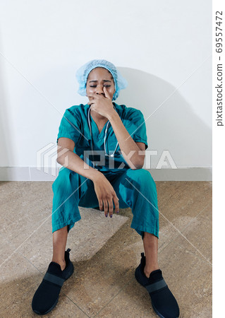 Crying exhausted young nurse Crying exhausted young nurse 69557472