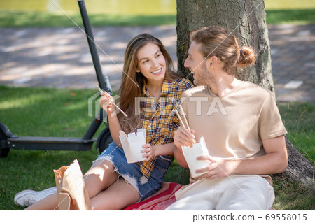 Young couple eating lunch and looking happy 69558015