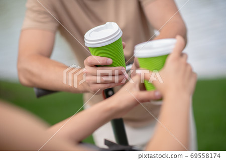 Close up picture of human hands with cups 69558174