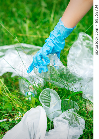 Hand of child cleans the park from plastic debris Hand of child cleans the park from plastic debris 69558734