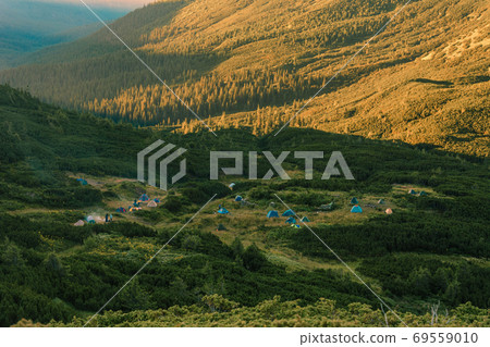 Sunrise in the Carpathians, on the Montenegrin saddle can be seen on the horizon tent camp, tents in the mountains, camping in the Carpathians. Sunrise in the Carpathians, on the Montenegrin saddle can be seen on the horizon tent camp, tents in the mountains, camping in the Carpathians. 69559010