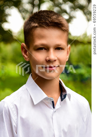 Portrait of a schoolboy in a white shirt near the school Portrait of a schoolboy in a white shirt near the school 69559219