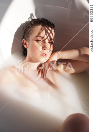 Young attractive woman relaxing in bath 69560351