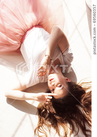 A portrait of a young woman, beautiful sunlight. She lies on a wooden floor 69560357