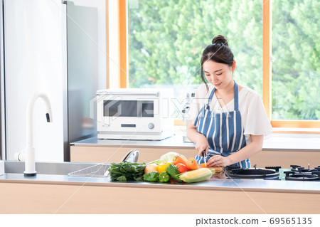 烹調在廚房裡的一位小姐 烹調在廚房裡的一位小姐 69565135