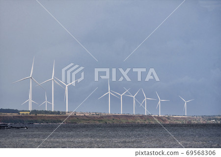 Wind wheels in the sea on blue sky background. Wind energy Wind wheels in the sea on blue sky background. Wind energy 69568306