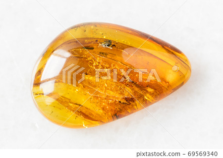 tumbled Amber gem stone on white marble tumbled Amber gem stone on white marble 69569340
