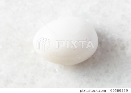 tumbled Milky Quartz rock on white marble 69569359
