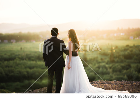 Romantic wedding moment, couple of newlyweds smiling portrait, bride and groom hugging 69569390