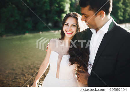 Wedding couple, groom and bride hugging, outdoor near river 69569494