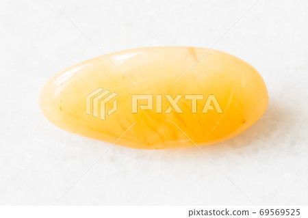 polished yellow chalcedony rock on white marble polished yellow chalcedony rock on white marble 69569525