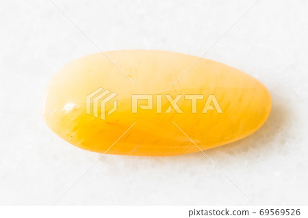 tumbled yellow chalcedony rock on white marble 69569526