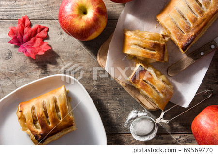 Traditional homemade apple strudel on wooden table Traditional homemade apple strudel on wooden table 69569770