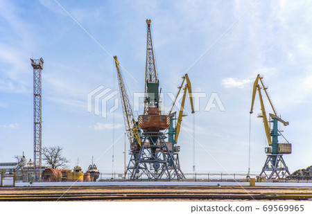 Sea port cargo cranes against the sky Sea port cargo cranes against the sky 69569965