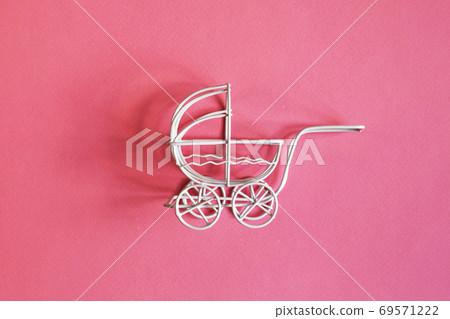 vintage toy baby stroller on a pink background. toy carriage 69571222