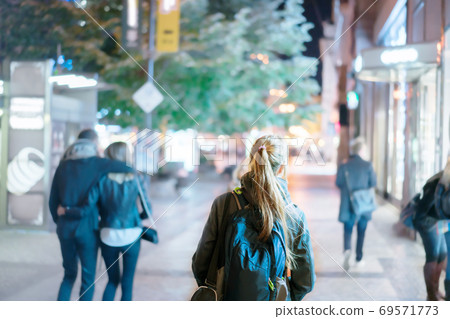 Back view of girl walking on city street at night, Prague Back view of girl walking on city street at night, Prague 69571773
