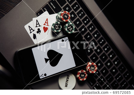 Poker chips, cards and smartphone on a grey keyboard. Poker online concept Poker chips, cards and smartphone on a grey keyboard. Poker online concept 69572085