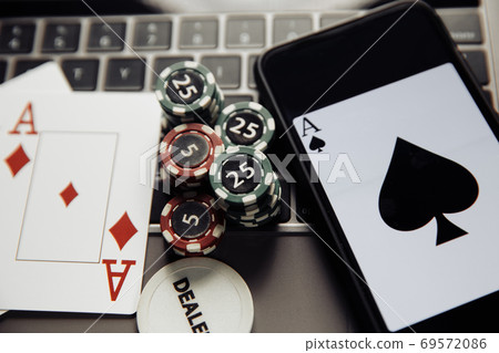 Poker play online. Poker chips, playing cards and smartphone on keyboard Poker play online. Poker chips, playing cards and smartphone on keyboard 69572086