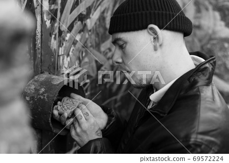 A thief picks the lock during a robbery. The criminal and his crime. Black and white photo. BW 69572224