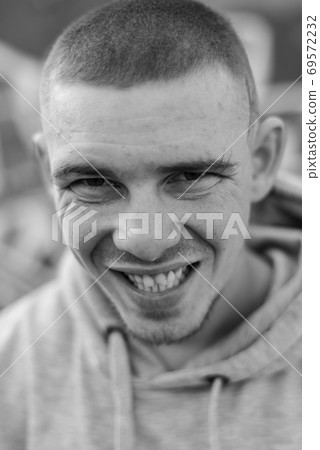 A bully guy in a light sports jacket with a hood. Black and white photo. BW 69572232