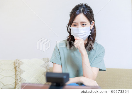 Woman receiving online medical treatment with a personal computer 69573264