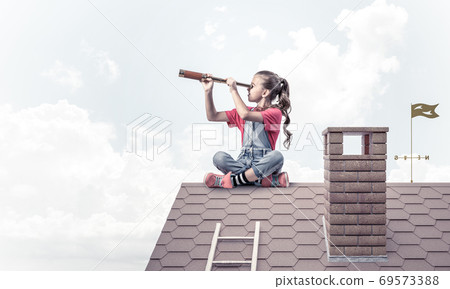 Concept of careless happy childhood with girl looking in spyglass 69573388