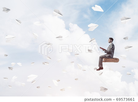 Businessman or student reading book and paper planes flying arou 69573661