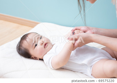 A woman who puts her baby on the floor A woman who puts her baby on the floor 69575220