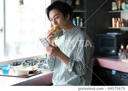 男人在廚房裡吃早餐 男人在廚房裡吃早餐 69575679
