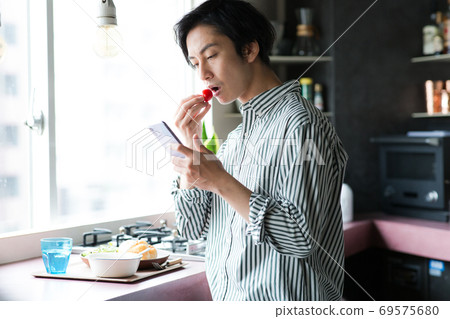 男人在廚房裡吃早餐 男人在廚房裡吃早餐 69575680
