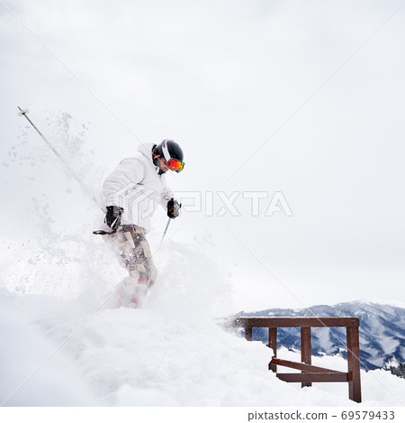 Winter kinds of sport. Skier doing tricks in the mountains in winter season 69579433