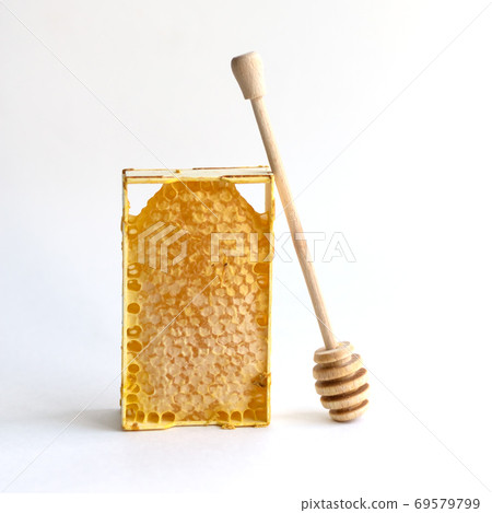 Fresh honey in a mini frame stands on a white background. Wooden spoon for honey. Reserve vitamins for the winter 69579799