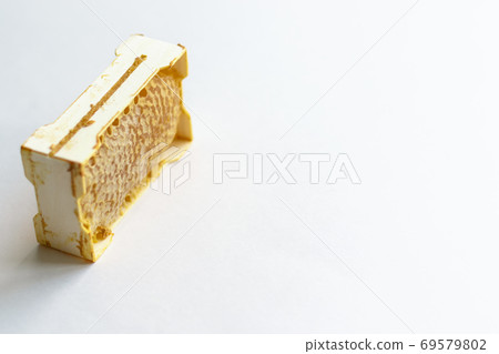 Fresh honey in a mini frame stands on a white background. Reserve vitamins for the winter. Lens soft focus Fresh honey in a mini frame stands on a white background. Reserve vitamins for the winter. Lens soft focus 69579802