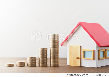 金錢和家庭縮影。與住房有關的金融和投資形象。堆放在木桌上的微型房子 金錢和家庭縮影。與住房有關的金融和投資形象。堆放在木桌上的微型房子 69580397