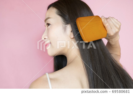 A woman stroking her hair A woman stroking her hair 69580681