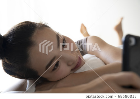 A woman watching a smartphone A woman watching a smartphone 69580815