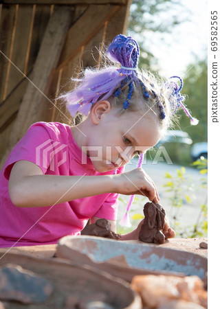 The child makes dishes and various figures from clay. Pottery skills. Hobbies and interests. Children's education, expanding horizons. The child makes dishes and various figures from clay. Pottery skills. Hobbies and interests. Children's education, expanding horizons. 69582565
