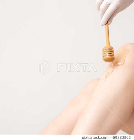 Wax flowing down on female leg 69583862