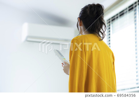 Woman with air conditioner Woman with air conditioner 69584356